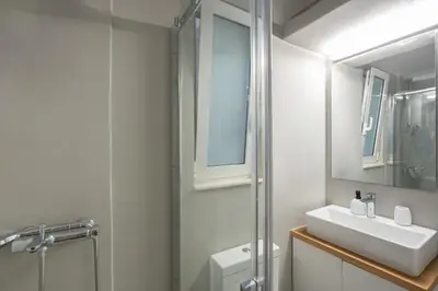 a bathroom with a sink and a shower and a mirror at Cozy Studio in Plaka 10 Minutes From Acropolis in Athens