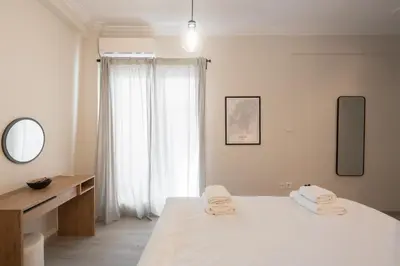 a white bedroom with a bed with towels on it at 1BR Apt with Backyard in Plaka 10 From Acropolis in Athens