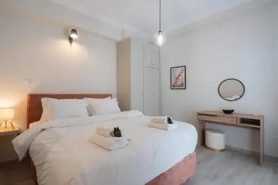 a bedroom with a large white bed with towels on it at 1BR Apt with Backyard in Plaka 10 From Acropolis in Athens