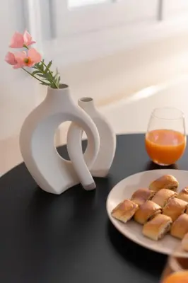 a plate of pastries and a vase with flowers and orange juice at 1BR Apt with Backyard in Plaka 10 From Acropolis in Athens