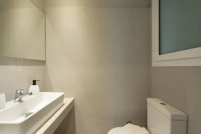 a white bathroom with a sink and a toilet at 1BR Apt with Backyard in Plaka 10 From Acropolis in Athens