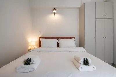 a bedroom with two white towels on a bed at 1BR Apt with Backyard in Plaka 10 From Acropolis in Athens