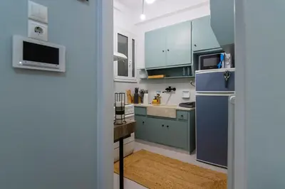 a kitchen with green cabinets and a blue refrigerator at Pangrati Subtle Deluxe Minimalism in Athens