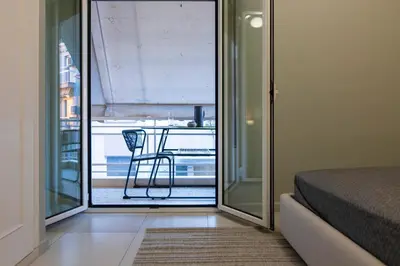 a room with a bed and a view of a balcony at Pangrati Subtle Deluxe Minimalism in Athens