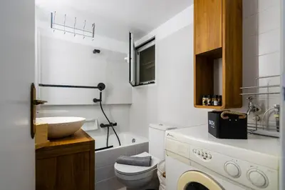 a white bathroom with a sink and a washing machine at Pangrati Subtle Deluxe Minimalism in Athens