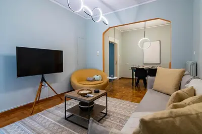 a living room with a couch and a tv and a table at Pangrati Subtle Deluxe Minimalism in Athens