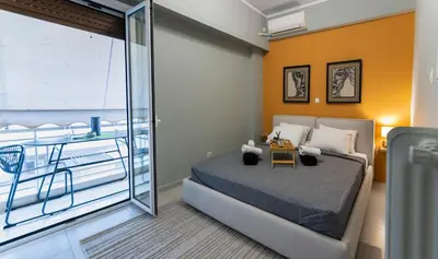 a bedroom with a large bed and a balcony at Pangrati Subtle Deluxe Minimalism in Athens