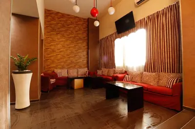 a living room with red couches and a brick wall at Athens Choice Hotel in Athens