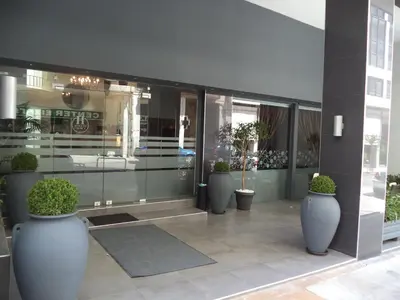 a group of potted plants in large vases on a building at Athens Choice Hotel in Athens