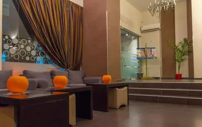 a lobby with a couch and orange chairs at Athens Choice Hotel in Athens