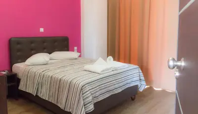 a bedroom with a bed with pink walls at Athens Choice Hotel in Athens