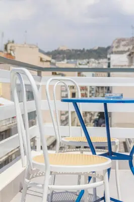 two chairs and a blue table on a balcony at Athens Choice Hotel in Athens