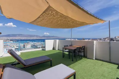 a balcony with a table and chairs and an umbrella at Apartment with a private rooftop in Piraeus