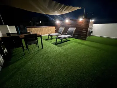 a room with two chairs and a table and green carpet at Apartment with a private rooftop in Piraeus