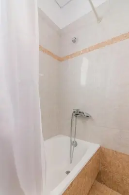 a white bath tub with a shower in a bathroom at Apartment with a private rooftop in Piraeus