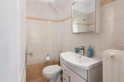 a bathroom with a sink and a toilet and a mirror at Apartment with a private rooftop in Piraeus