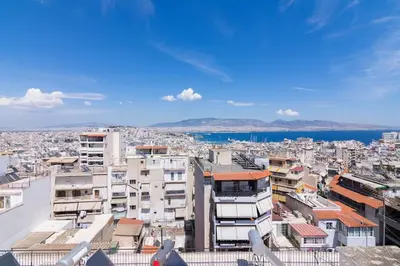 a view of a city with buildings and the water at Apartment with a private rooftop in Piraeus