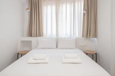 a bedroom with a white bed with two towels on it at Centric Romantic Studio Zen Clio, Tessera Urban Apartments in Athens