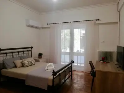 a bedroom with a bed and a large window at Modern Studio for 2 persons in the Heart of Athens in Athens