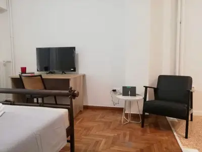 a bedroom with a bed and two chairs and a tv at Modern Studio for 2 persons in the Heart of Athens in Athens