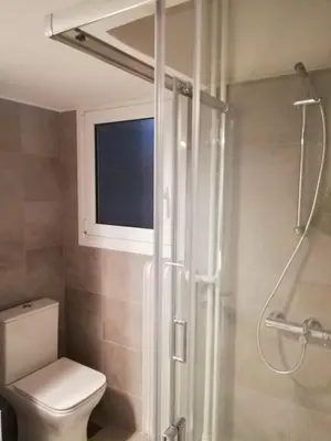 a bathroom with a toilet and a shower with a window at Modern Studio for 2 persons in the Heart of Athens in Athens