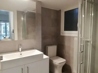 a bathroom with a toilet and a sink and a mirror at Modern Studio for 2 persons in the Heart of Athens in Athens
