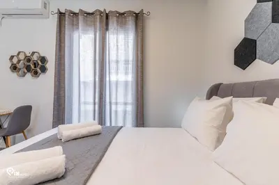 a bedroom with a large white bed and a window at Simple and Comfy - Modern Urban Escape in Egaleo-Athens in Athens