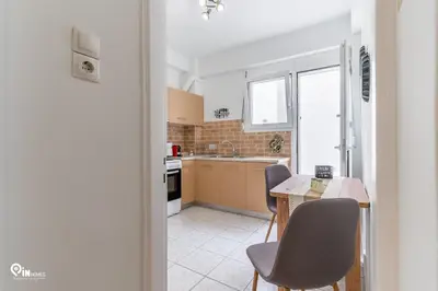 a kitchen with a table and chairs and a sink at Simple and Comfy - Modern Urban Escape in Egaleo-Athens in Athens