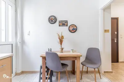 a kitchen with a wooden table and two chairs at Simple and Comfy - Modern Urban Escape in Egaleo-Athens in Athens