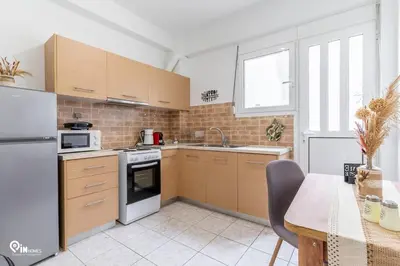 a kitchen with wooden cabinets and a white refrigerator at Simple and Comfy - Modern Urban Escape in Egaleo-Athens in Athens