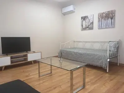 a living room with a bed and a tv at Olvia 10 in Athens