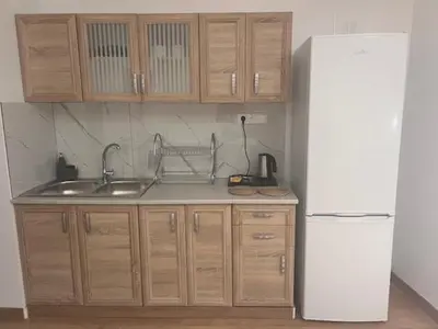 a kitchen with wooden cabinets and a white refrigerator at Olvia 10 in Athens