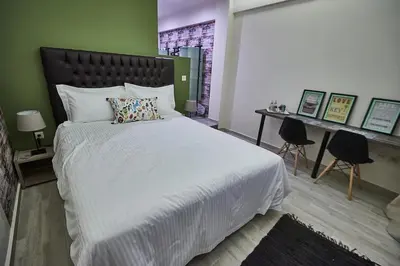 a bedroom with a large white bed and a desk at Lycabettus View 2, brand-new, central, cozy studio in Athens