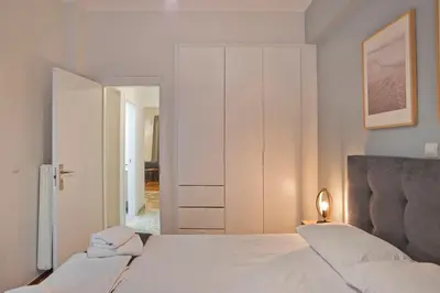 a white bedroom with a bed and a closet at Charming Kallithea Apt, fully Reno, Fully Equipped in Athens