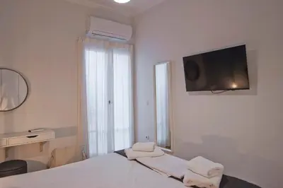 a white bedroom with a bed with towels on it at Charming Kallithea Apt, fully Reno, Fully Equipped in Athens