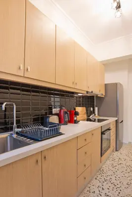 a kitchen with wooden cabinets and a sink at Charming Kallithea Apt, fully Reno, Fully Equipped in Athens