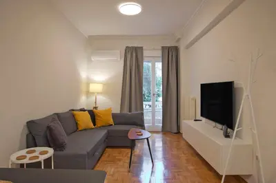a living room with a couch and a flat screen tv at Charming Kallithea Apt, fully Reno, Fully Equipped in Athens