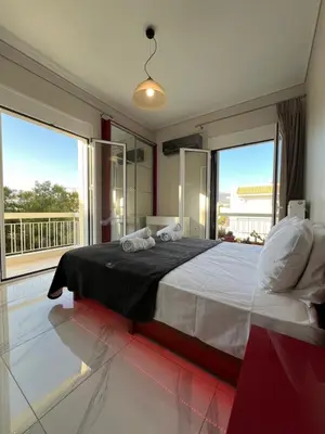a bedroom with a large bed and large windows at Sea La Vie, Glyfada in Athens