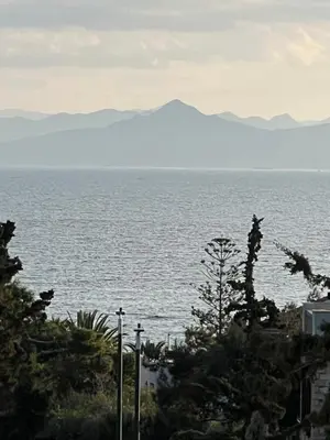 a view of the ocean with mountains in the distance at Sea La Vie, Glyfada in Athens