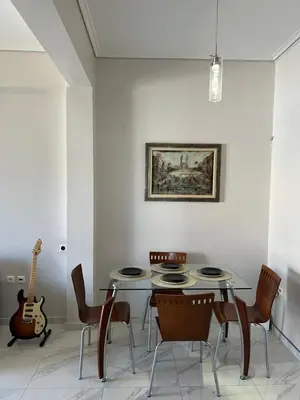a dining room with a table and chairs and a guitar at Sea La Vie, Glyfada in Athens