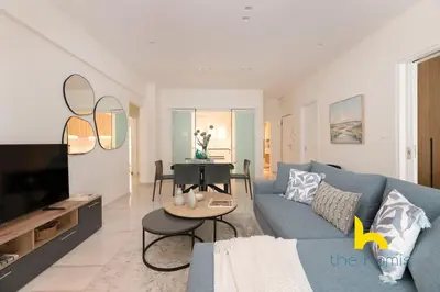 a living room with a blue couch and a table at Radiant 3BR in Pireas Near Marina Zeas and Metro in Piraeus