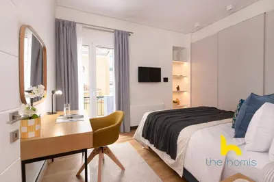 a bedroom with a bed and a desk and a mirror at Radiant 3BR in Pireas Near Marina Zeas and Metro in Piraeus