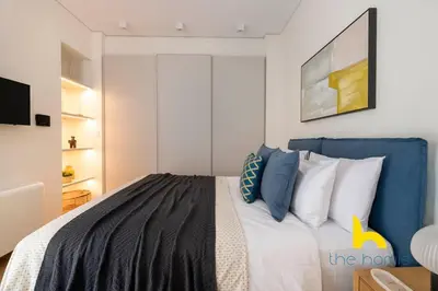 a bedroom with a bed with blue and white pillows at Radiant 3BR in Pireas Near Marina Zeas and Metro in Piraeus