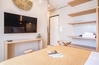a room with a table and a tv on the wall at Acropolis Museum Studios in Athens