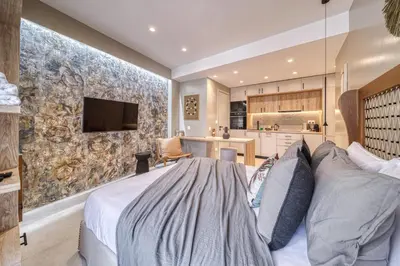 a bedroom with a large bed and a kitchen at Acropolis Museum Studios in Athens