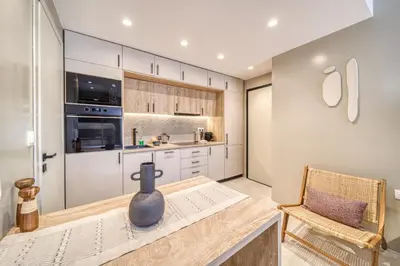 a kitchen with white cabinets and a vase on a table at Acropolis Museum Studios in Athens