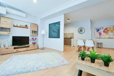 a living room with a television and a table and chairs at 2 Bedroom Apartment near Piraeus Port B1 in Piraeus