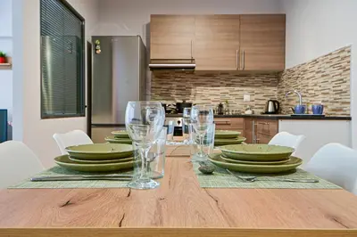 a dining room table with plates and glasses on it at 2 Bedroom Apartment near Piraeus Port B1 in Piraeus