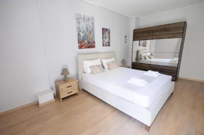 a bedroom with a large white bed and a mirror at 2 Bedroom Apartment near Piraeus Port B1 in Piraeus