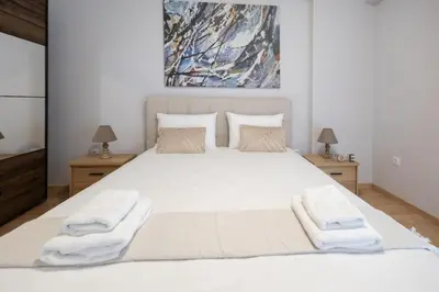 a bedroom with a large white bed with towels on it at 2 Bedroom Apartment near Piraeus Port B1 in Piraeus